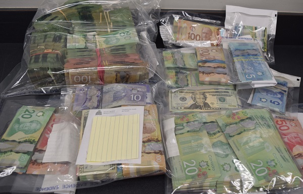 Large quantity of currency bundled in elastic bands and stored in bags while being displayed on a table