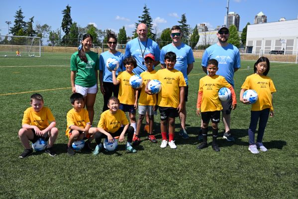 Des enfants sourient en plein air, &agrave; c&ocirc;t&eacute; de policiers.