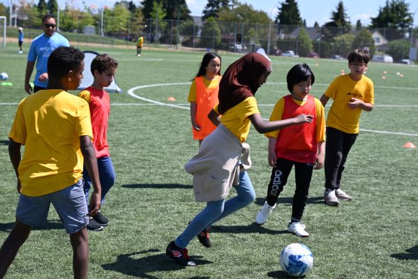 Un groupe d&rsquo;enfants joue au soccer en plein air.