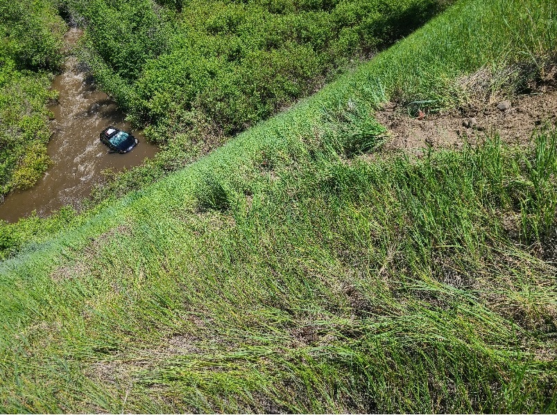 Car from distance resting in Hat Creek with slope in foreground