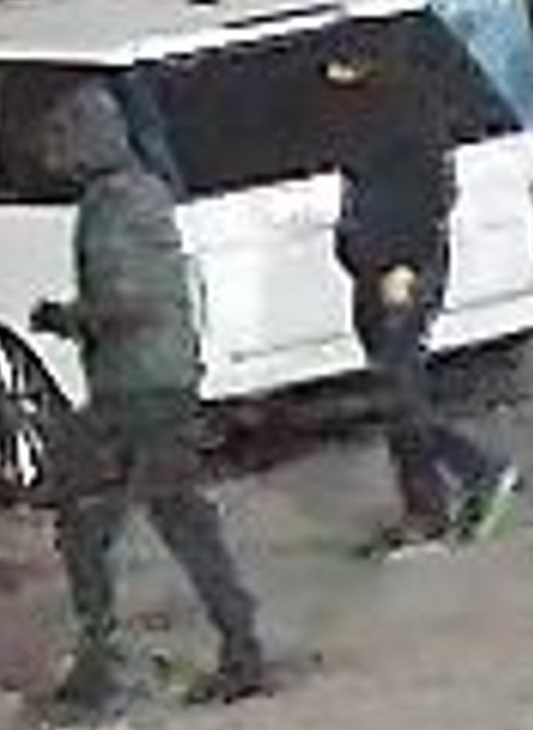 Photo of two individuals walking, both wearing dark clothing and their faces are not visible.