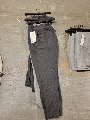 Men&rsquo;s jogging pants on hangers piled on the ground