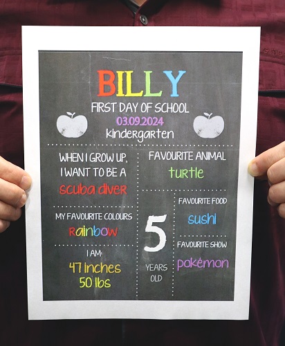 RCMP officer holds a back to school placard with children&rsquo;s personal information