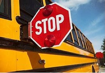 side of a yellow school bus with a red stop sign extended