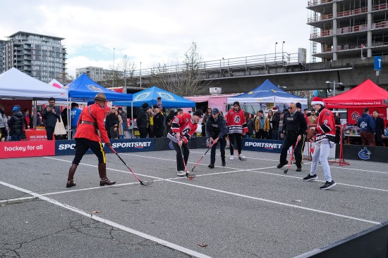 RCMP officers and Richmond Sockeyes playing ball hockey with community members