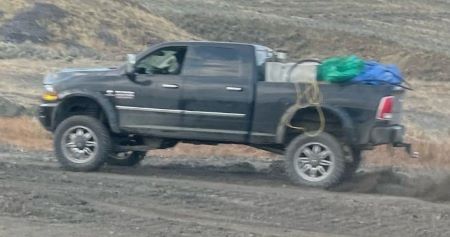 camionnette sombre &agrave; quatre portes remplie d&rsquo;objets &agrave; l&rsquo;arri&egrave;re.