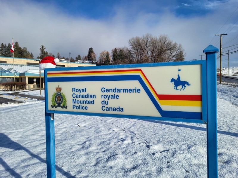The Merritt RCMP Detachment Sign with a Santa hat on it, out front of the Merritt RCMP Detachment. 
