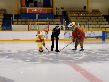 RCMP Safety Bear and Kitimat Fire Department's Sparky face off center ice with Sgt Rob Gardner dropping the puck