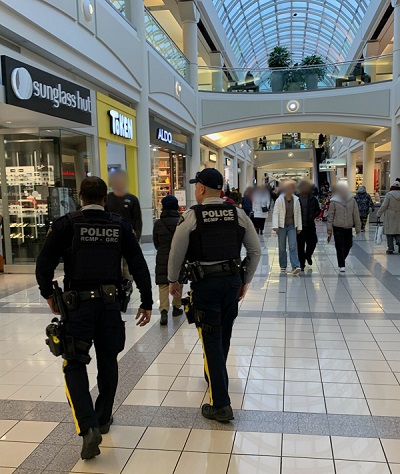 Two RCMP officers walking through the mall wearing full RCMP uniforms