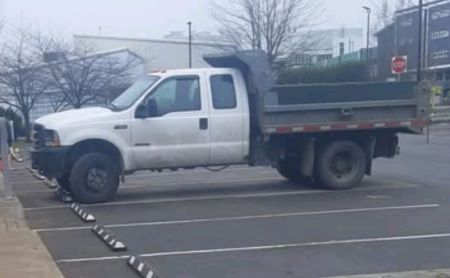 white 2003 Ford F550 Dumper truck parked in a parking lot