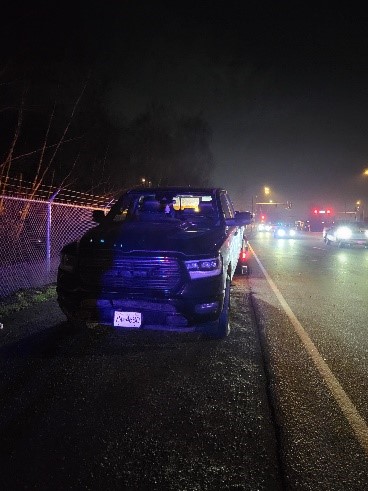 Black pickup truck attached to a tow truck