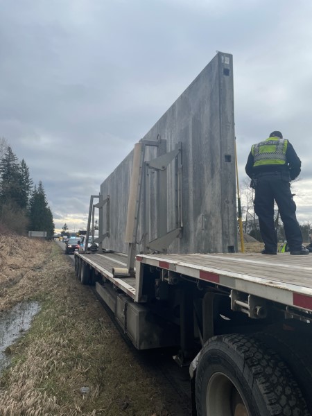 BC Highway Patrol and CVSE officers examine the load that struck both the 264 overpass and the CP Rail overpass on Highway #1 westbound