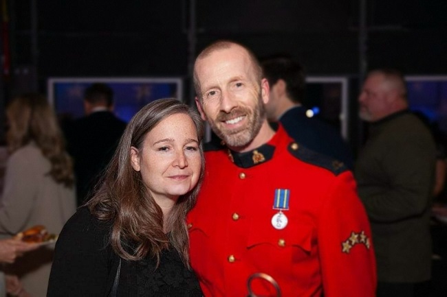 Photo of Cpl. Scotty Schumann, wearing his RCMP red serge uniform along with his wife attending an event.