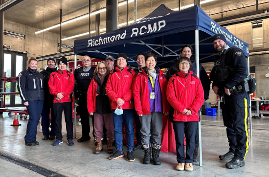 Representatives from Richmond RCMP and Richmond Fire standing with Richmond RCMP volunteers inside a Fire Hall
