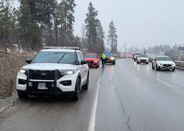 A Kelowna BC Highway Patrol police officer stops a driver to deliver education on Slow Down Move Over