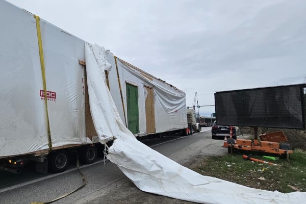 A tractor-trailer with a damaged load after an overpass strike on Highway #99