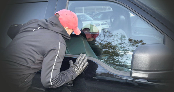 Man in red hat and gloves peeking into a car window