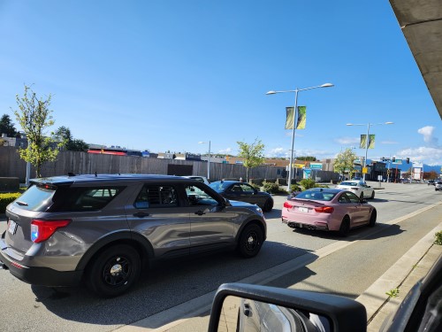 unmarked police vehicle stopped behind a pink BMW sedan