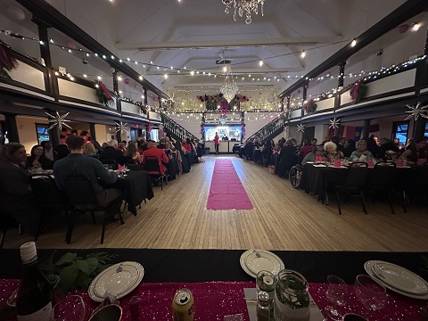 Guests sitting at banquet tables in decorated community hall