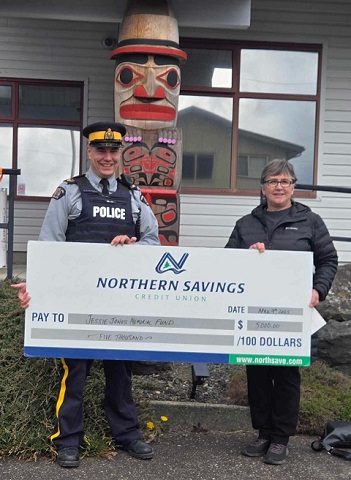 Sgt. Chris Manseau giving donation cheque to Jesse Jones Memorial Fund representative outside the Daajing Giids Detachment