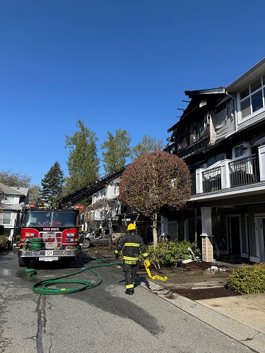 Photo of a firefighter walking towards the damages and firetruck