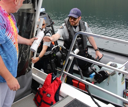 Police officers conducting safety check on boat operator.