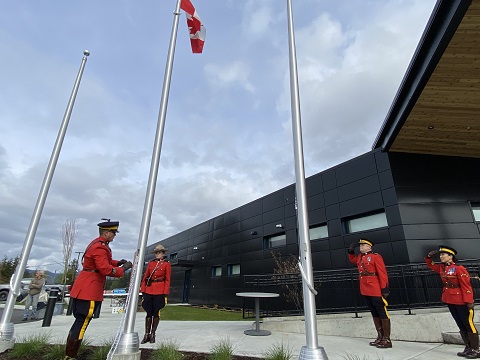 Four RCMP officers wearing Red Serge at the flagpole