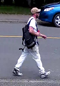 suspect wearing a white t-shirt, walking on the street 