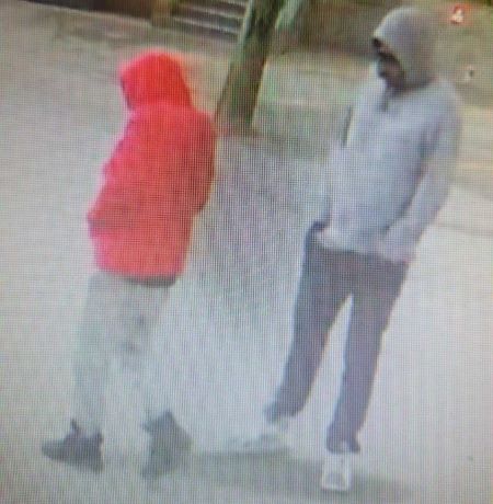 Les deux suspects sont debout &agrave; l&rsquo;ext&eacute;rieur, les mains dans les poches. 