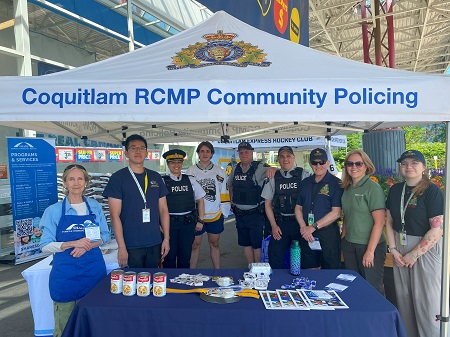 Group photo of Coquitlam RCMP Officers, staff, SHARE Society and Coquitlam Express hockey players