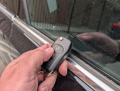 photo of a hand locking the vehicle with a key fob