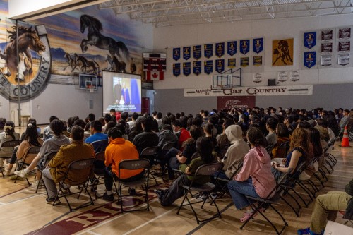 Students watching presentation in school gymnasium