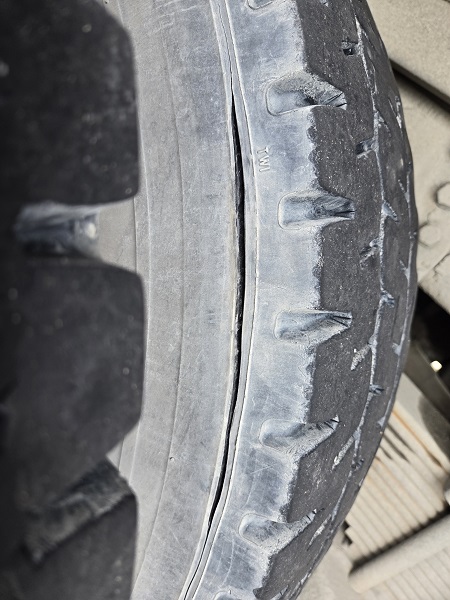 A commercial vehicle tire with an 8-inch gash.