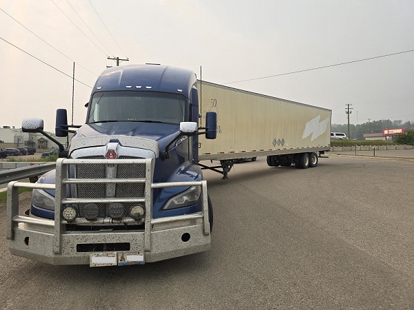A tractor-trailer stopped with a broken rear axle that sheared off in the parking lot of the Fort Nelson post office