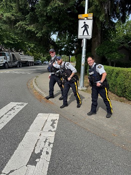 Trois membres en uniforme se tiennent au coin d&rsquo;une rue