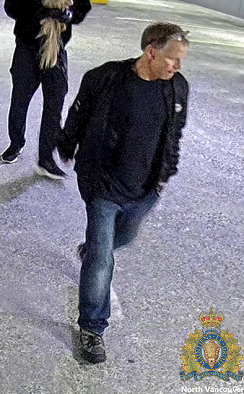 CCTV image of Suspect 1, described as a Caucasian male with short, balding hair, a stocky build, wearing a black jacket, dark T-shirt, and blue jeans.