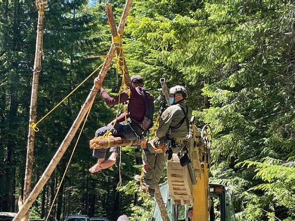 Photo of individual being removed from an unstable tripod structure