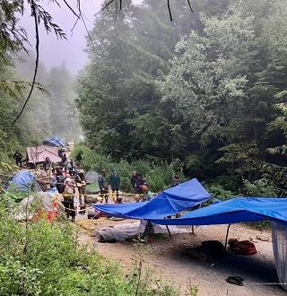 protesters under tarps on gravel road