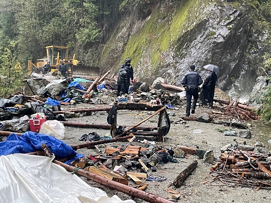 Photo of officers removing an individual from a trench in the road
