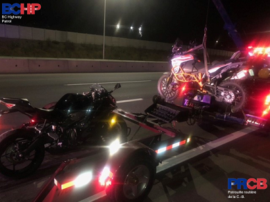 Photo de deux motos attach&eacute;es &agrave; un chariot de remorquage derri&egrave;re une d&eacute;panneuse