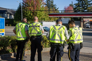 View of uniformed officers from behind as they look toward the roadway