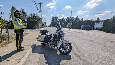 Photo of Constable Scott standing next to police motorcycle