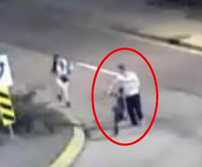 Male wearing a white shirt walking beside a bike and Kristina Ward beside him.