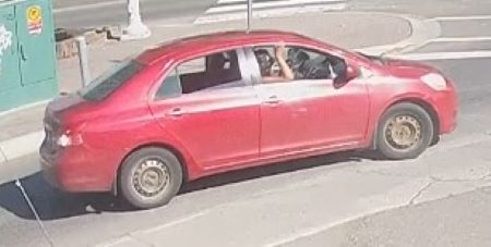 A red four-door sedan with no hub caps