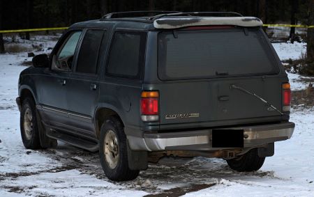 An older model green Ford Explorer - back. 