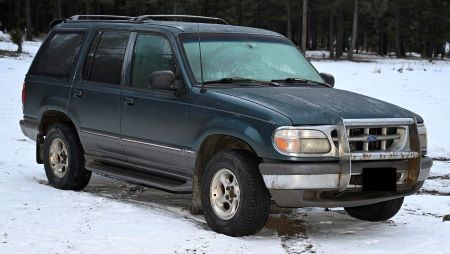 An older model green Ford Explorer - front. 