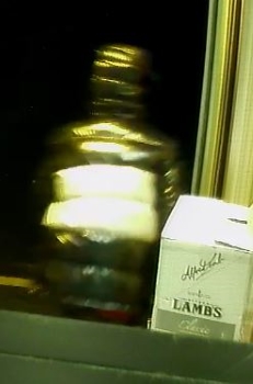 Le deuxi&egrave;me suspect sortant du magasin. Il porte un manteau noir et blanc brillant dont le capuchon est relev&eacute;. 