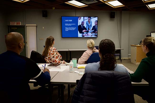 Discussing case studies at workshop. Students sitting around a table. 