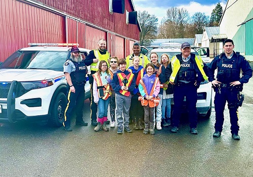 photo of police car, polie officers, and students